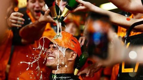 Lando Norris has champagne poured over him after winning the F1 drivers' championship
