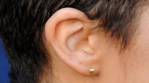 A picture of a woman's ear side on.