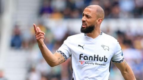 Kemar Roofe points to the crowd during a match for Derby