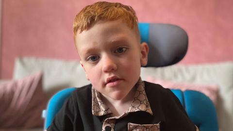 Image of Harrison looking at the camera in his wheelchair.