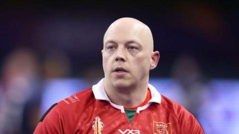 Scott John Trigg-Turner, a bald man in a red rugby jersey.