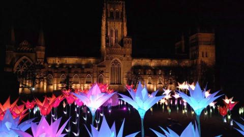 Durham cathedral with a garden of lights in the shape of flowers for Lumiere