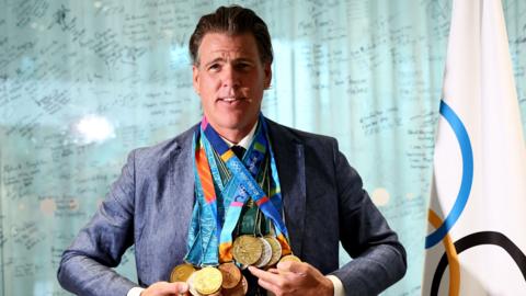 Former USA swimmer Gary Hall Jr wears all 10 of his replica Olympic medals given to him by the International Olympic Committee