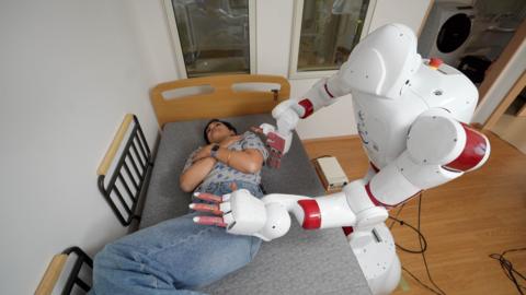 AIREC robot turning over a person at Waseda University in Tokyo