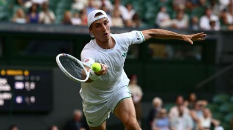 Joe Salisbury plays a forehand at Wimbledon