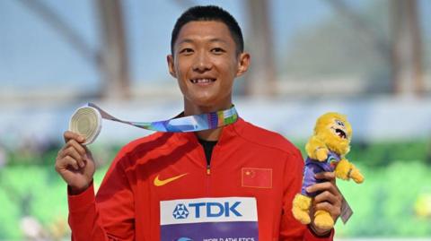 China's Wang Jianan poses on the podium after winning long jump gold at the World Championships in Oregon in 2022