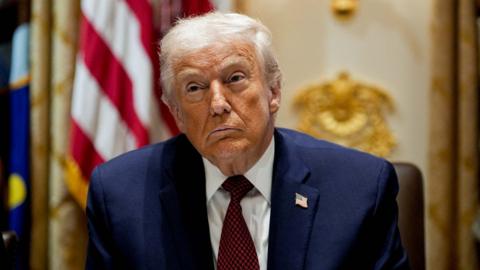 Donald Trump in a navy suit with a red tie