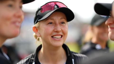 Fran Wilson standing talking to her Somerset team-mates