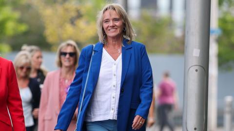 Sandie Peggie outside the employment tribunal building in a white shirt and blue jacket