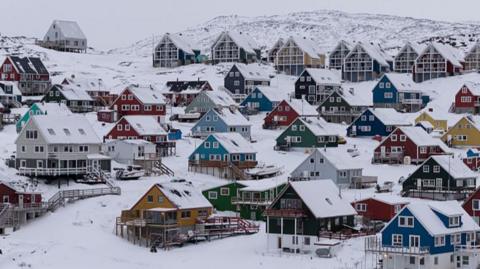 Colourful, A-line houses in the snow.