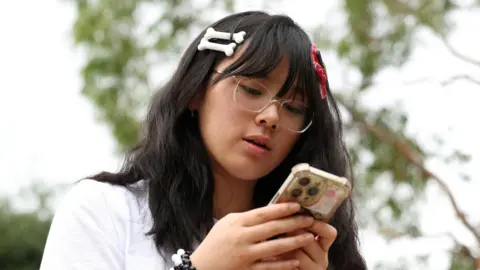 nnie Wang, 14, poses after an interview discussing Australia’s social media ban for users under 16, which is scheduled to take effect on December 10, in Sydney, Australia, November 22, 2025