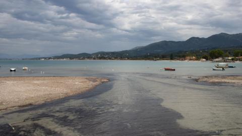 A picture of a beach, with a large peninsula in the distance