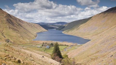 A view down to the Talla Reservoir, a body of water surrounded by rugged countryside