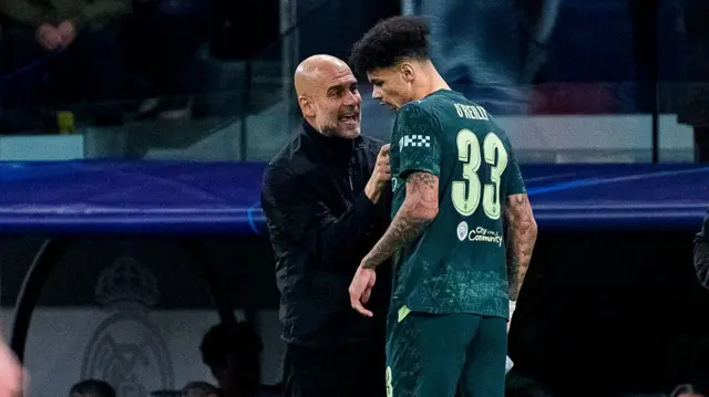 Pep Guardiola speaks to Nico O'Reilly