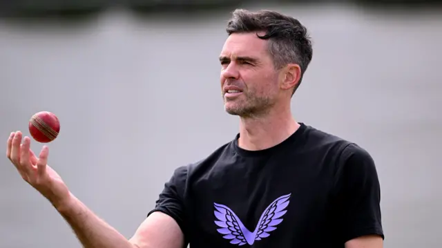 Former England bowler James Anderson tosses a ball in the air