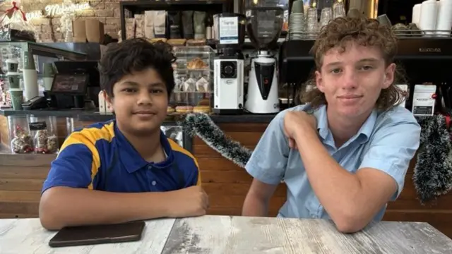 Two teenage boys sitting in a cafe