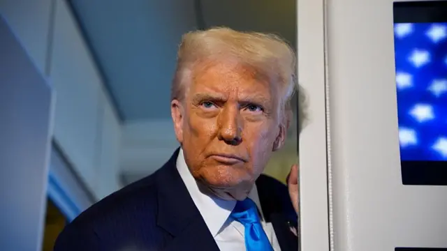 Trump wearing a dark blue suit over a white shirt and bright blue tie