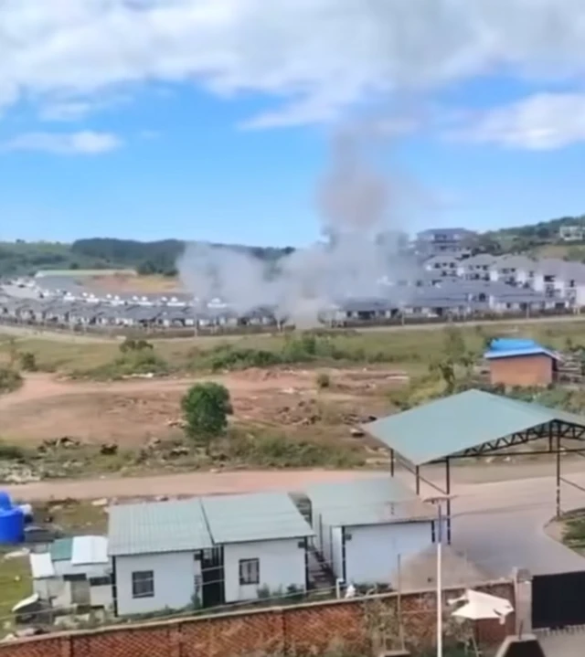 A smoke cloud rises over a buildings in a construction site