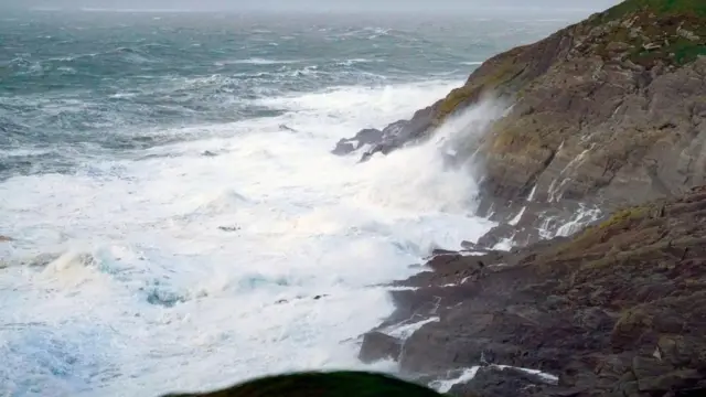 Waves crashing in Kinsale, Co. Cork. Every county in the Republic of Ireland will be under an orange weather warning at some point on Tuesday, according to upgraded advisories from Irish forecasters.