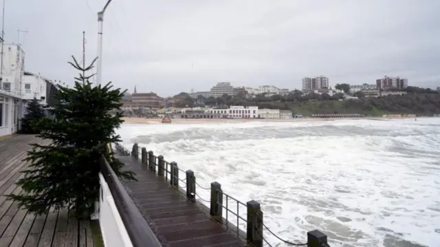 Rough seas in Bournemouth, England, with windswept Christmas tree