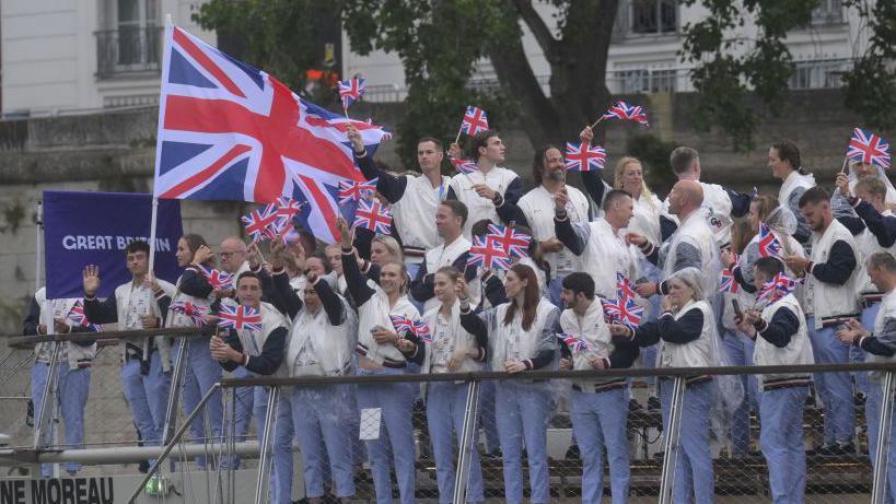 Team GB athletes wave from a boat sailing down the River Seine at the 2024 Paris Olympic Games opening ceremony