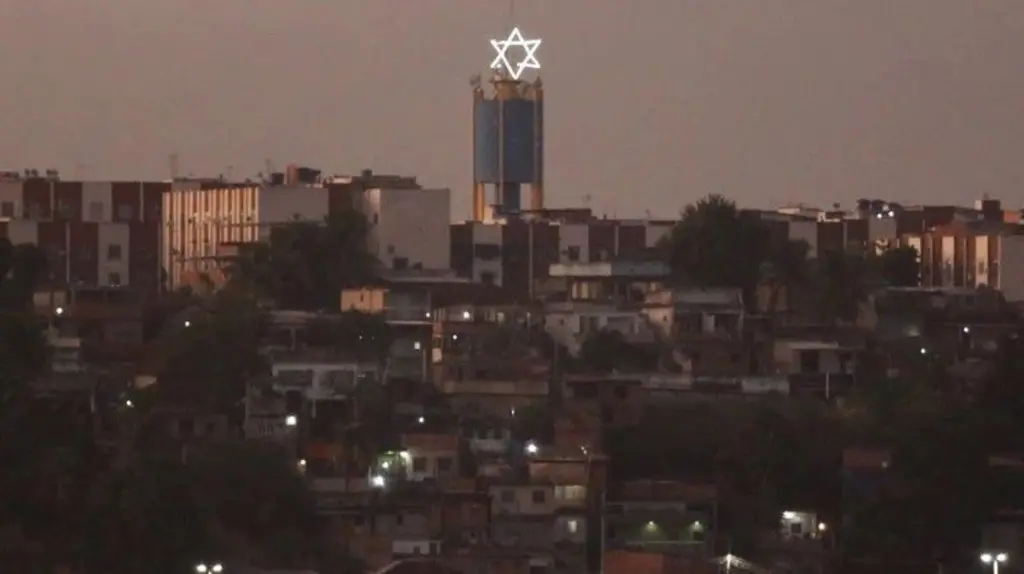 Imagem de casas no Complexo de Israel. A estrela de Davi está no alto de uma torre