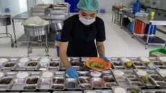 Petugas menyiapkan paket MBG di salah satu SPPG di Padang, Sumatera Barat.