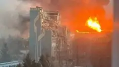 Yonayotgan ko'p qavatli uy tasviri. Olov va tutun va vayron bo'lgan baland bino