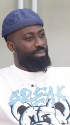 Agba Inaki wọ aṣọ funfun, fila olomi aro, o n wo ẹgbẹ