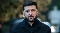 Koyu renk gömlek giyinmiş Zelenskiy kameraya bakıyor