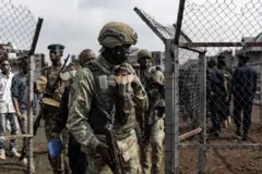 Un membre du mouvement M23 observe l'enrôlement de civils, de policiers et d'anciens membres des Forces armées de la République démocratique du Congo (FARDC) qui auraient décidé de rejoindre volontairement le mouvement M23 à Goma, le 23 février 2025.