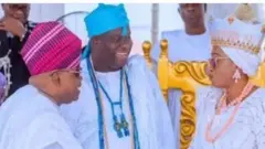 Gomina Ademola Adeleke to duro sapa alaafia wọ asọ agbada ati sokoto funfun pẹlu fila alawọ waini pẹlu Ọọni tilu Ile Ife, Oba Adeyeye Ogunwusi, ẹni ti oun naa wọ asọ agbada funfun ati ade alawọ buluu pẹlu ọpọ ilẹkẹ ti wọn jẹ alawọ buluu bakan naa, n ba aya aarẹ, Oluremi Tinubu to wa iro ati buba funfun ati ade funfun lori.