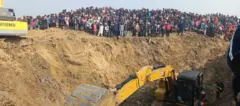 শিশুটিকে উদ্ধারের জন্য গর্তের চারপাশ থেকে এক্সকাভেটর দিয়ে মাটি খনন করা হচ্ছে। সেখানে উৎসুক জনতার ভিড়।