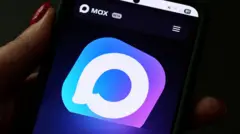 На темном фоне левая рука человека с накрашенными красным лаком ногтями держит смартфон. На экране смартфона написано Max и изображен светло-фиолетовый логотип со стилизованным окошком сообщения.