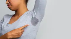 በልብሷ ላይ የብብቷ ላብ የሚታይ ሴት