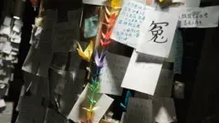 哀悼者摆放的摺纸,伴着一张纸写上“冤”纸条。