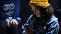 دختری در حال نگاه کردن به گوشی موبایل