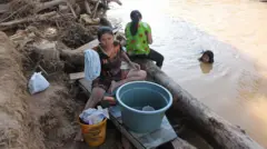 Warga mencuci pakaian di lokasi desa yang terdampak banjir besar dan tanah longsor di Desa Huta Nabolon, Kecamatan Tukka, Kabupaten Tapanuli Tengah, Sumatera Utara, Rabu (03/12).