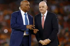 Le président de la Confédération africaine de football (CAF), Patrice Motsepe discute avec le président de la FIFA, Gianni Infantino sur le podium après la victoire de la Côte d'Ivoire en finale de la CAN 2024 contre le Nigeria, au stade olympique Alassane Ouattara d'Ebimpe, à Abidjan, le 11 février 2024.