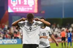 حمزة عبد الكريم اللاعب المصري الشاب رقم 9 في منتخب مصر - بقميص أبيض رقم 9 يصمّ أذنيه بعد تسجيل هدف