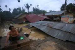 Seorang warga korban banjir berada di samping rumahnya yang hancur setelah diterjang banjir bandang di Desa Sungai Liput, Kecamatan Kejuruan, Aceh Tamiang, Aceh, Selasa (02/12).