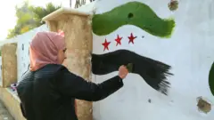 Женщина в Дейр-эз-Зоре рисует граффити на стене