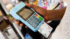 Ọwọ to mu ẹrọ PoS dani pẹlu kaaki Opay ninu rẹ