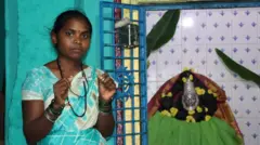 Шилпа бўйнидаги маржонини кўрсатмоқда.