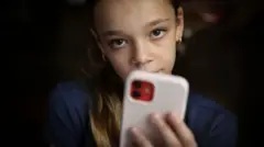 الفتاة إيزوبيل تحمل هاتفها.