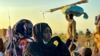 صورة أرشيفية لامرأة سودانية نازحة، تستريح في منطقة طويلة، في إقليم دارفور غربي البلاد الذي مزقته الحرب، في 28 أكتوبر/تشرين الأول 2025، بعد فرارها من الفاشر عقب سقوط المدينة في أيدي قوات الدعم السريع. تُظهر الصورة السيدة التي ترتدي عباءة سوداء ويغطي شعرها حجاب أسود، بينما تضع يدها أسفل حدها الأيسر.