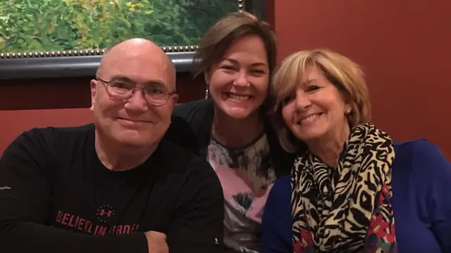 一张照片中,卡罗尔先生、黛比与韦伯女士在餐桌旁微笑合影。