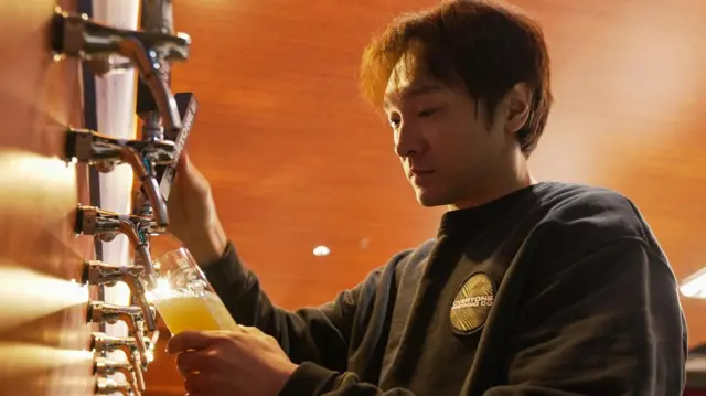 工作人员在精酿啤酒厂弦外之音酿造啤酒。