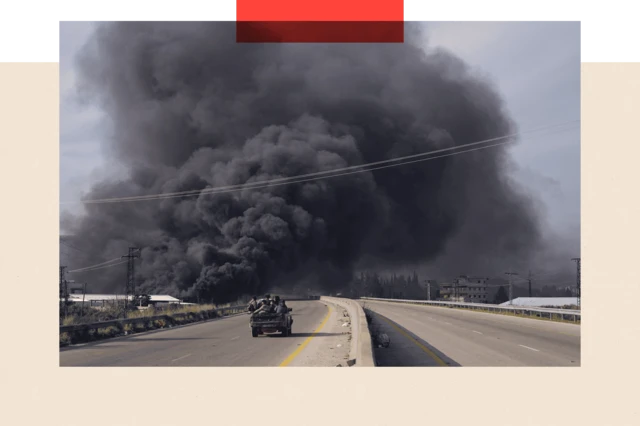 A massive cloud of black smoke behind a car