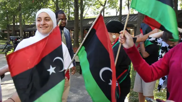 أعضاء من منظمة "ليبيون من أجل الحرية" يحتفلون أمام مبنى ميكي ليلاند الفيدرالي في هيوستن عام 2011، بعد سقوط حكم معمر القذافي.